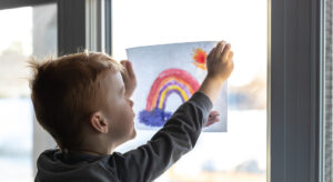 Covid 19 effetti sui bambini
Bambino affacciato alla finestra con arcobaleno "andrà tutto bene"